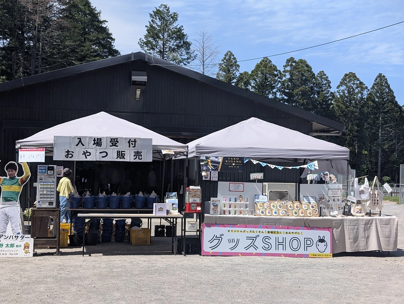 入場受付とおやつ販売のテント。奥にグッズショップ
